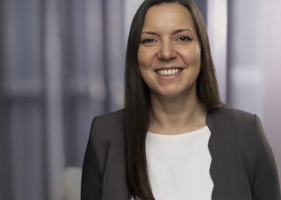Businessfoto Frau mit langen dunklen Haaren in grauem Blazer